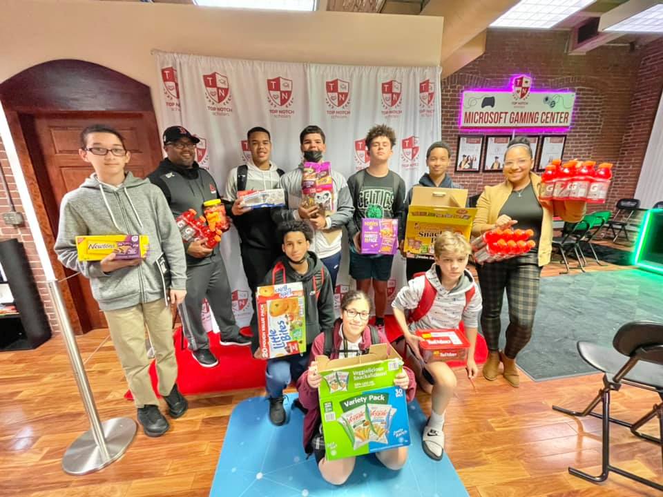 group of top notch scholars with food donation items